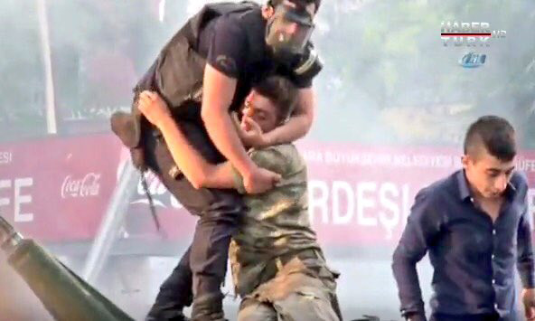 Hình ảnh cảnh sát Thổ Nhĩ Kỳ ôm lính đảo chính bị người dân ném đồ vật và giẫm đạp gây xúc động. Ảnh chụp từ clip.