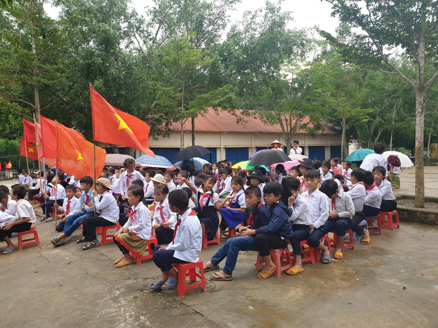 Học sinh trường Tiểu học Bán trú Vừ A Dính che dù dự lễ khai giảng.