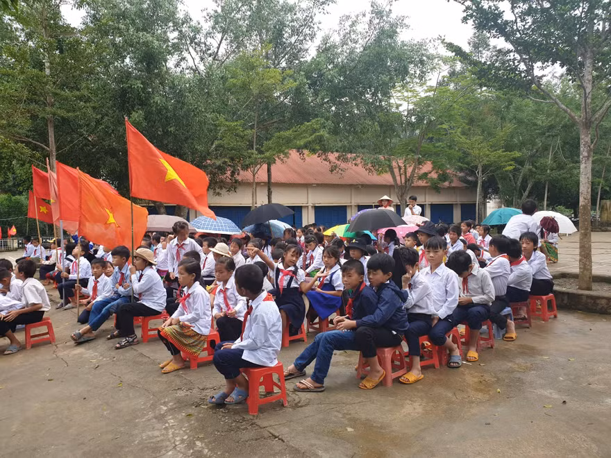 Học sinh trường Tiểu học Bán trú Vừ A Dính che dù dự lễ khai giảng.