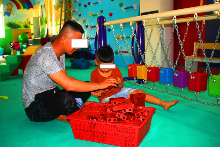 Một phụ huynh đưa con tham gia lớp tập huấn kỹ năng chăm sóc trẻ bị rối loạn phổ tự kỷ