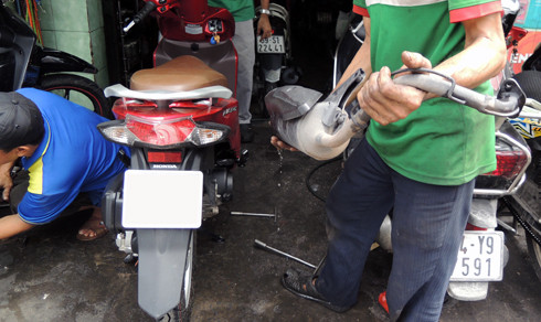 Thợ sửa xe tháo một ống xả bên trong chứa đầy nước.