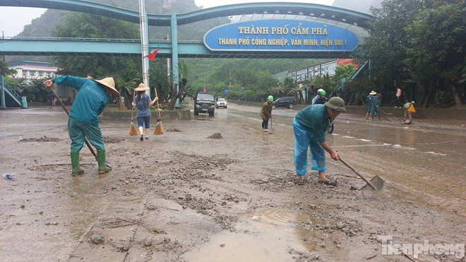 Công nhân môi trường thành phố Hạ Long tiến hành dọn bùn, rác thải đọng trên mặt đường.