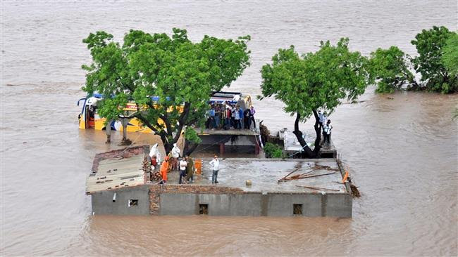 Nước dâng cao, người dân ở huyện Amreli phải trèo lên tòa nhà cao tầng chờ lực lượng cứu hộ 