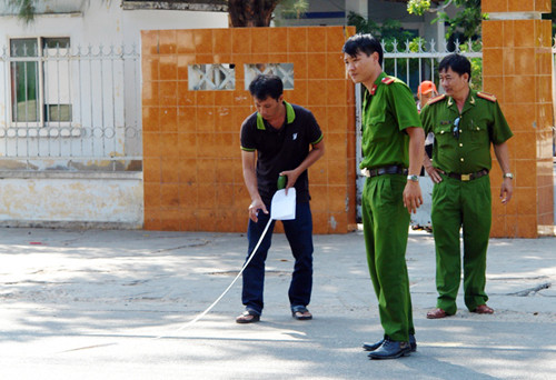 Cảnh sát khám nghiệm hiện trường vụ án mạng trước cổng trường. Ảnh: Tư Huynh