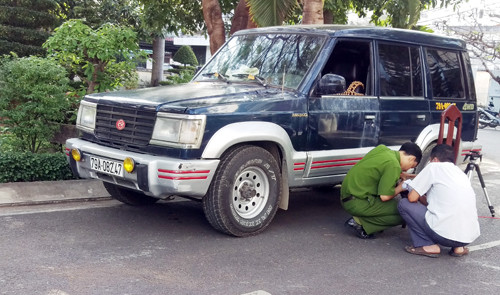 Cảnh sát khám nghiệm chiếc ôtô của nạn nhân. Ảnh: Xuân Ngọc