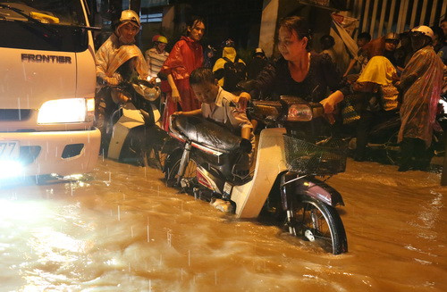 Người dân phải dẫn qua đoạn đường ngập ở phường Tân Hòa. Ảnh: Phước Tuấn.