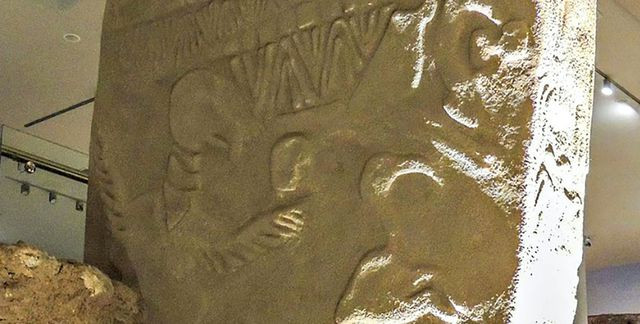 Phiến đá cổ xưa với những hình chạm khắc.