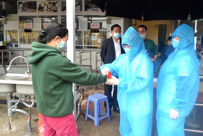 Người dân vào Bệnh viện đa khoa Sơn Tây sẽ phải đo thân nhiệt, khai báo y tế và đóng dấu xác nhận đã được kiểm soát. Ảnh: Đức Vân - Vũ Tuyết