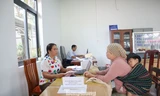 Cán bộ xã dùng song ngữ giúp dân làm thủ tục hành chính