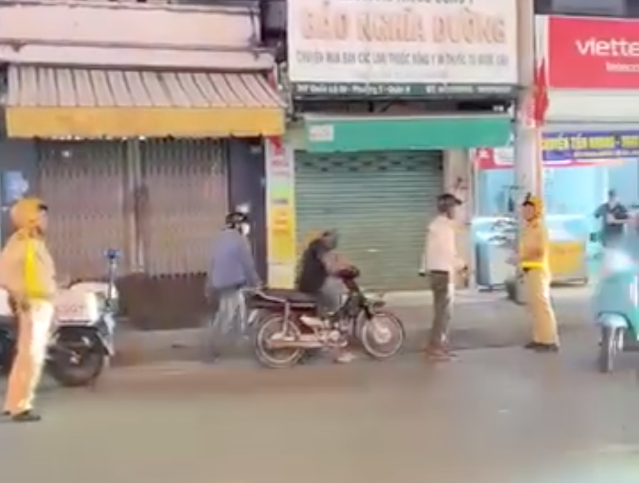 3 người đàn ông đi xe máy có hành vi chống đối lực lượng CSGT. Ảnh cắt từ clip. tan-cong-csgt-2.png