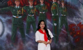 Một bạn trẻ phấn khởi khi check-in tại con đường bích họa.