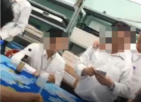 Hình ảnh giáo viên đánh bài tại thư viện Trường Tiểu học Vĩnh Phú. Ảnh cắt từ clip.