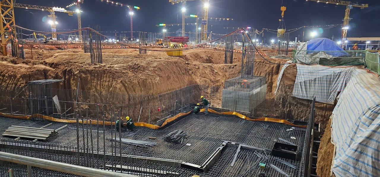 Màn đêm buông xuống, cũng lúc hàng ngàn bóng đèn cao áp từ trên các trụ tháp cần cẩu cao hàng chục mét rọi xuống công trường sáng như ban ngày.