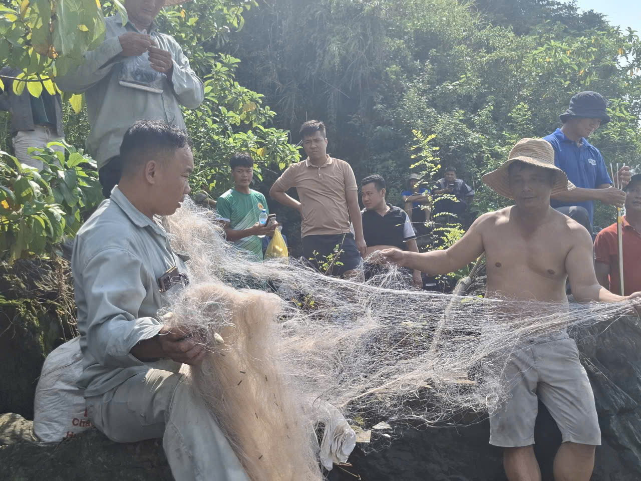 Một số người chuẩn bị cả lưới, ngư cụ để xuống chân đập Trị An bắt cá