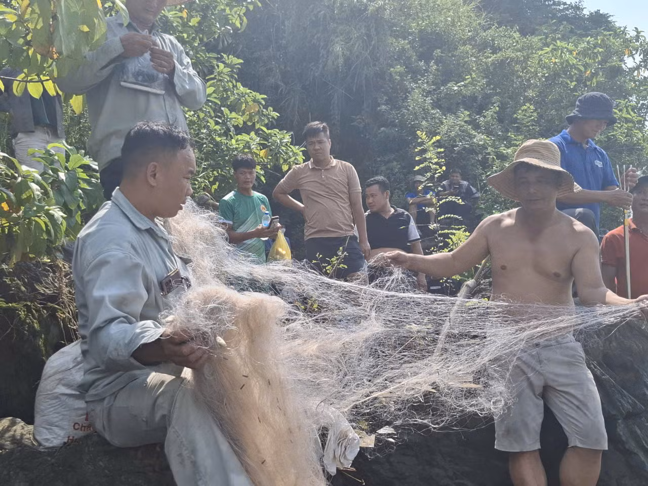Một số người chuẩn bị cả lưới, ngư cụ để xuống chân đập Trị An bắt cá