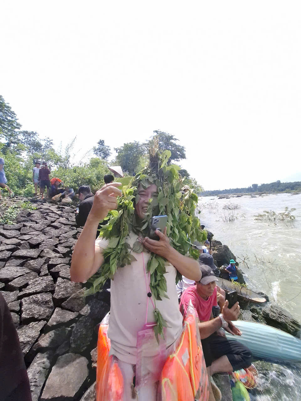 Một thanh niên đến từ TPHCM đội nắng xem người dân bắt cá