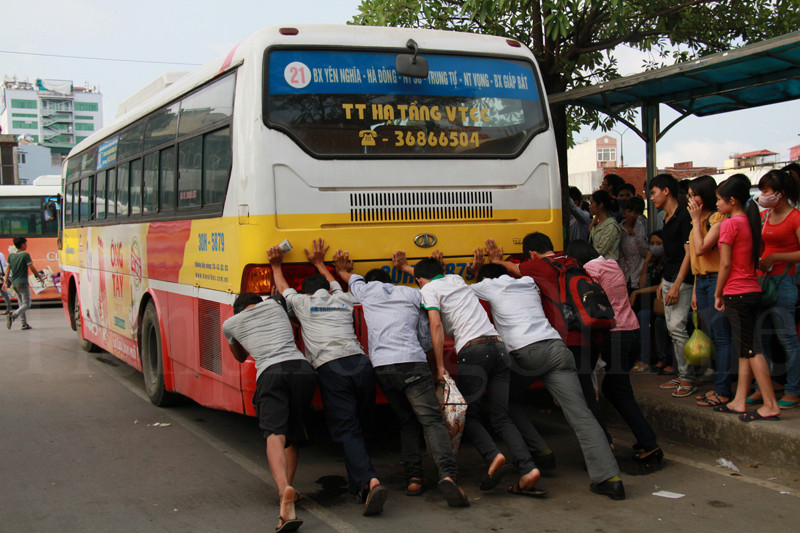 Một chiếc xe buýt bị chết máy, phải huy động nguồn nhân lực tại chỗ để khởi động. Ảnh: Trường Phong