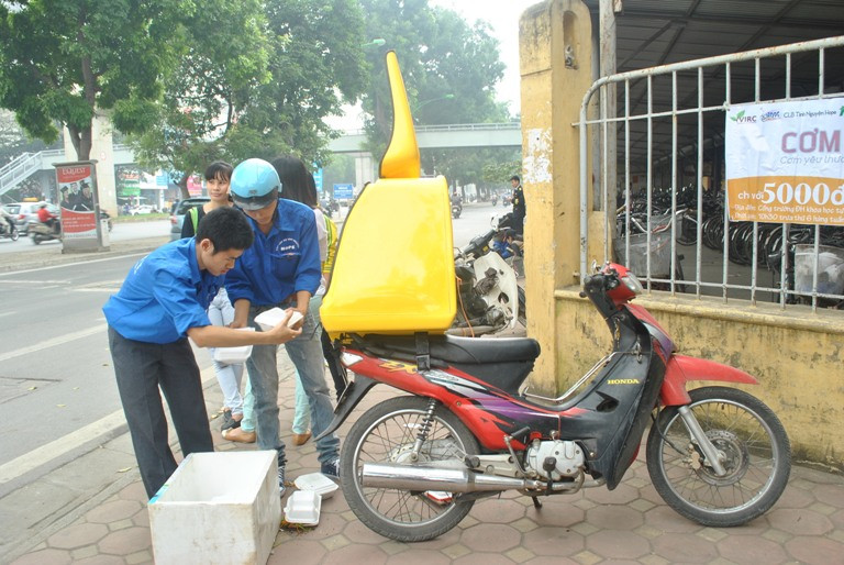 Các tình nguyện viên CLB Hope mang cơm đến cổng trường 