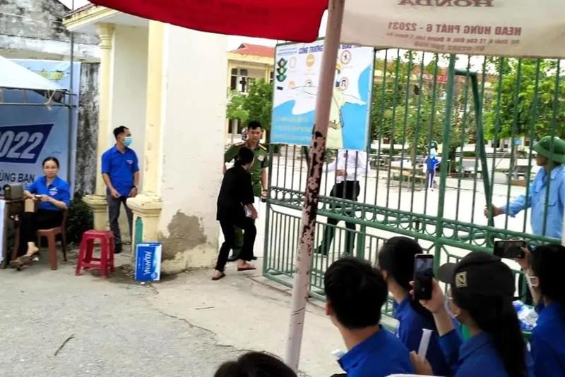 Một thí sinh ở Nghệ An chạy như bay vào cổng trường khi được chiến sĩ công an chở tới ngay sát giờ thi. Ảnh: Internet