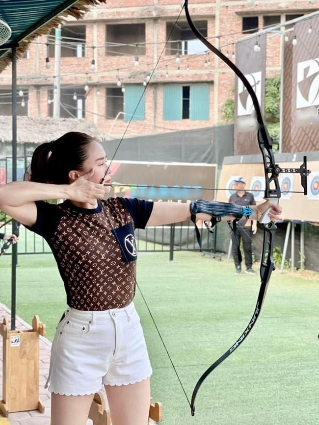 Hồng Diễm khoe vẻ đẹp mạnh mẽ, khỏe khoắn khi tập trung bắn cung. - Ảnh: FBNV.