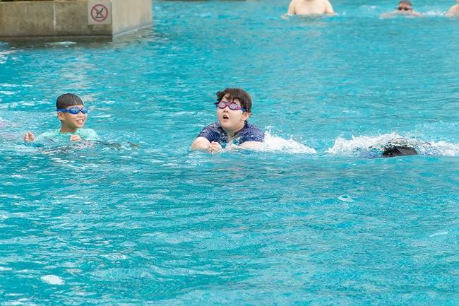 Cậu bé giỏi bơi lội và hòa đồng cùng bạn bè.