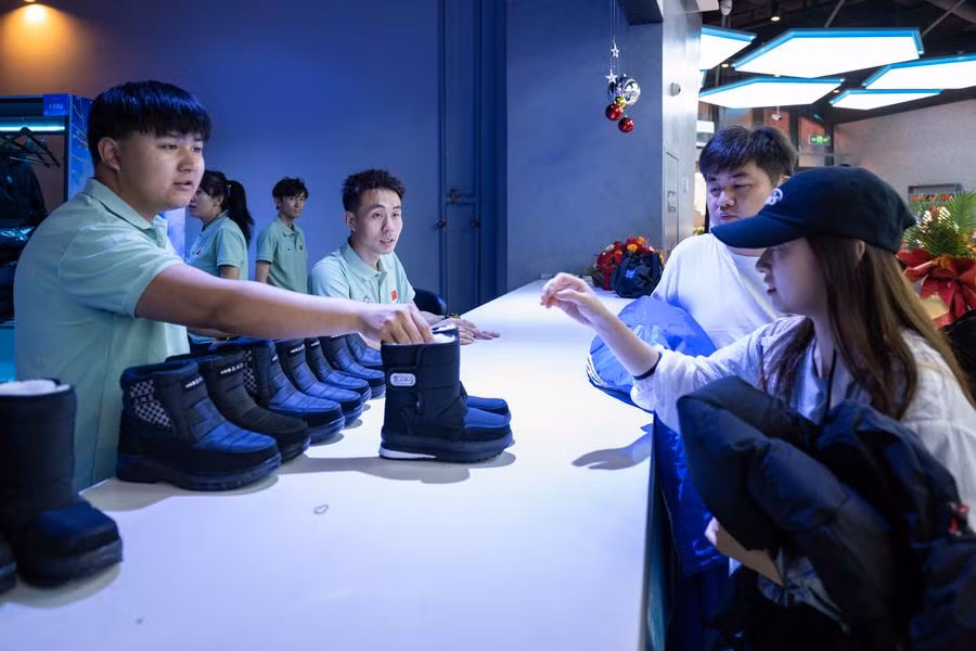 Du khách thuê quần áo chống lạnh trước khi vào công viên. Ảnh: Xinhua.