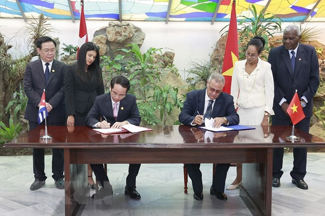 Chủ tịch Quốc hội Vương Đình Huệ và Chủ tịch Quốc hội Cuba chứng kiến lãnh đạo tỉnh Quảng Trị trao số tiền 50.000 USD tặng thành phố Santiago de Cuba cùng thỏa thuận hợp tác giữa hai địa phương. (Ảnh: Doãn Tấn/TTXVN)