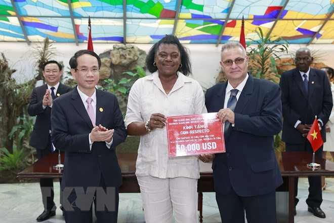 Chủ tịch Quốc hội Vương Đình Huệ và Chủ tịch Quốc hội Cuba chứng kiến lãnh đạo tỉnh Quảng Trị trao số tiền 50.000 USD tặng thành phố Santiago de Cuba cùng thỏa thuận hợp tác giữa hai địa phương. (Ảnh: Doãn Tấn/TTXVN)