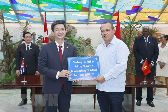 Chủ tịch Quốc hội Vương Đình Huệ và Chủ tịch Quốc hội Cuba chứng kiến lãnh đạo tỉnh Quảng Trị trao 50.000 USD tặng tỉnh Holquín cùng thỏa thuận hợp tác giữa hai địa phương. (Ảnh: Doãn Tấn/TTXVN)