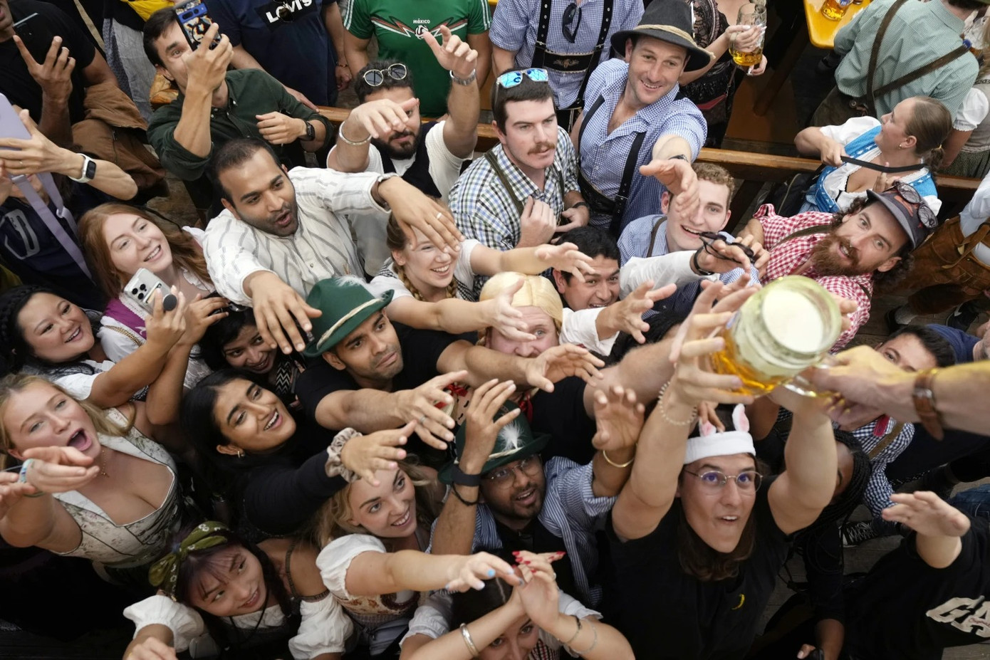 Du khách vui sướng tranh nhau những ly bia đầu tiên trong lễ hội dân gian lớn nhất thế giới này. Ảnh: AP.