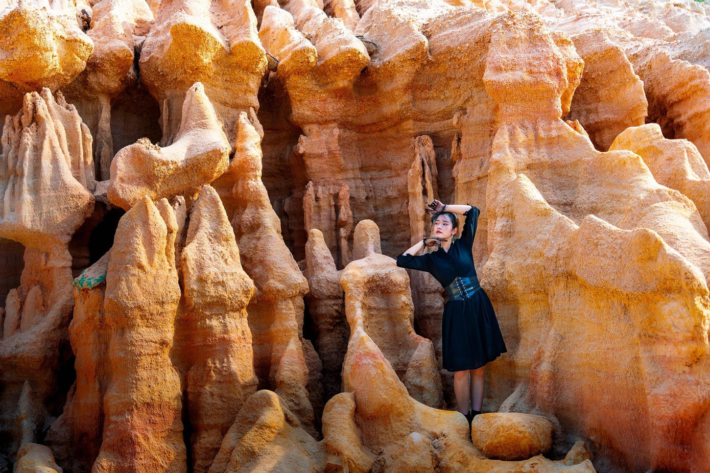 Du khách chọn trang phục tối màu để nổi bật hơn giữa những vách đá màu nâu đất có hình thú độc đáo (Ảnh: Phạm Công Quý). Du khách chọn trang phục tối màu để nổi bật hơn giữa những vách đá màu nâu đất có hình thú độc đáo (Ảnh: Phạm Công Quý).