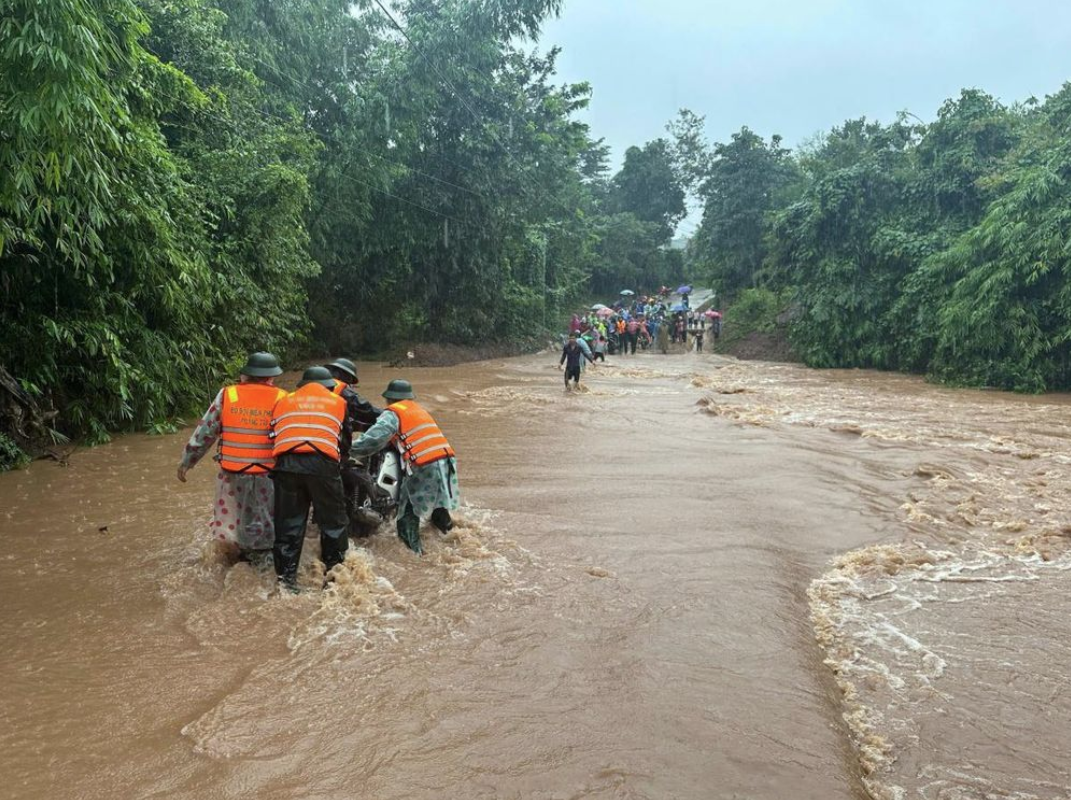Cán bộ, chiến sĩ Đồn Biên phòng Thanh, BĐBP Quảng Trị giúp nhân dân di chuyển phương tiện khi qua ngầm tràn.