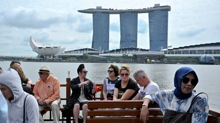 Khách du lịch đi thuyền bumboat với khách sạn nghỉ dưỡng Marina Bay Sands ở phía sau. Khu nghỉ dưỡng đã giúp thúc đẩy ngành du lịch của thành phố. Ảnh: Reuters.