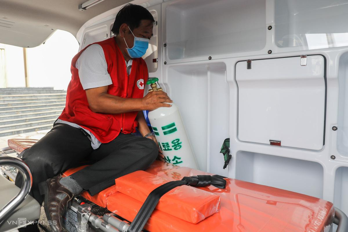 Anh Minh (tài xế) gắn bình oxy vào ngăn chuyên dụng trên xe trực cấp cứu.