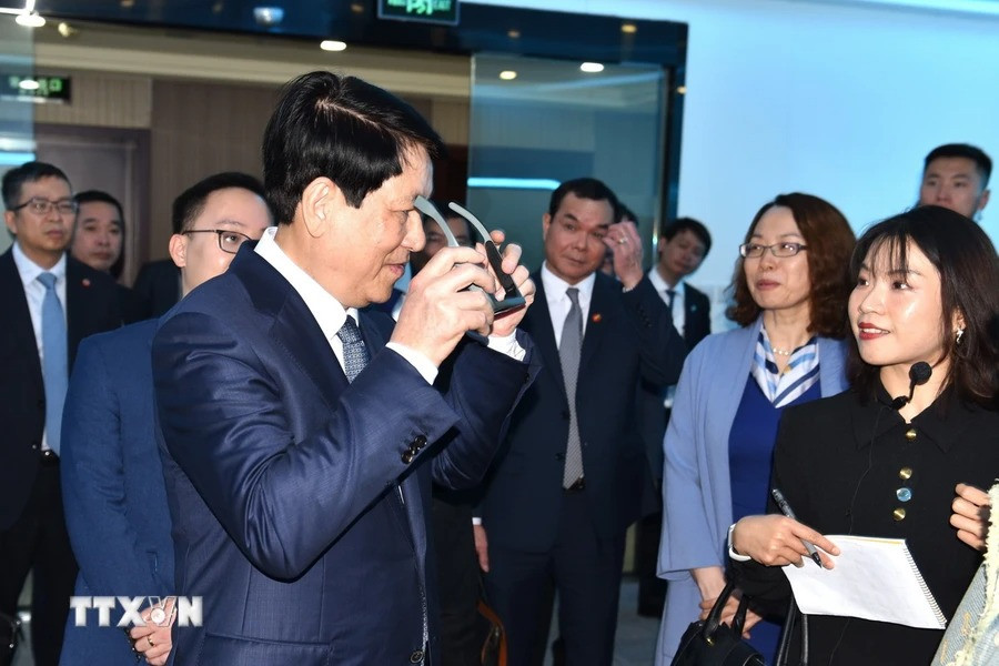 Đồng chí Lương Cường trải nghiệm một số sản phẩm của Công ty kỹ thuật cao LL Vision. (Ảnh: Thành Dương/TTXVN)