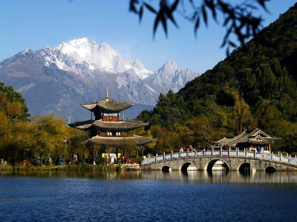 Khung cảnh mùa thu ở Vân Nam với hồ nước trong xanh và đỉnh Ngọc Long phủ đầy tuyết trắng. Ảnh minh họa: Internet.