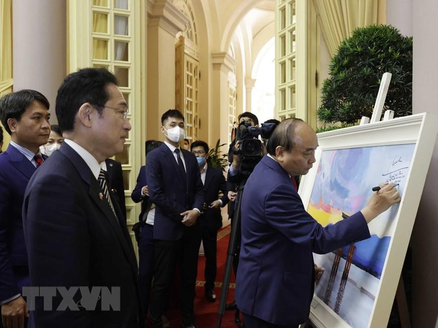 Chủ tịch nước Nguyễn Xuân Phúc ký tặng Thủ tướng Nhật Bản Kishida Fumio tác phẩm hội họa của họa sỹ Việt Nam về phong cảnh Nhật Bản. (Ảnh: Thống Nhất/TTXVN)