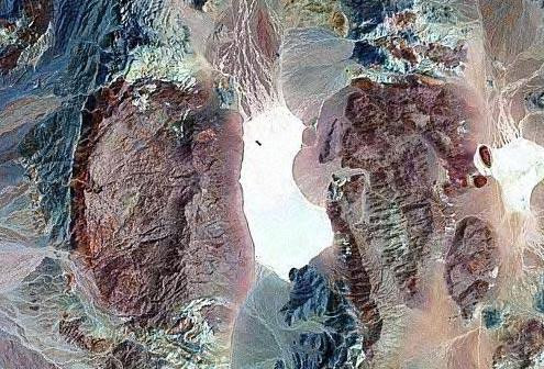 Thung lũng chết – Death Valley nằm gần biên giới bang California và Nevada, toạ lạc ở nơi thấp nhất, khô nhất và nóng nhất Bắc Mỹ. Vùng đất này trải dài trên 136,2km và có diện tích 7.800km2, nằm ở độ sâu 86m dưới mực nước biển. Tại đây có một chiếc hồ khô Racetrack Playa và những hòn đá lớn nhỏ (có hòn đá nặng tới 320kg), điều đặc biệt là chúng có khả năng tự di chuyển và để lại phía sau những vệt dài trên nền đất nứt nẻ. Hồ Racetrack Playa chụp từ vệ tinh. (Ảnh: Geology.com) Thung lũng chết – Death Valley nằm gần biên giới bang California và Nevada, toạ lạc ở nơi thấp nhất, khô nhất và nóng nhất Bắc Mỹ. Vùng đất này trải dài trên 136,2km và có diện tích 7.800km2, nằm ở độ sâu 86m dưới mực nước biển. Tại đây có một chiếc hồ khô Racetrack Playa và những hòn đá lớn nhỏ (có hòn đá nặng tới 320kg), điều đặc biệt là chúng có khả năng tự di chuyển và để lại phía sau những vệt dài trên nền đất nứt nẻ. Hồ Racetrack Playa chụp từ vệ tinh. (Ảnh: Geology.com)