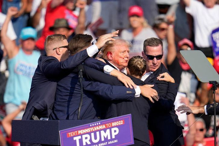 Các mật vụ Mỹ nhanh chóng đưa ông Trump rời khỏi sân khấu.