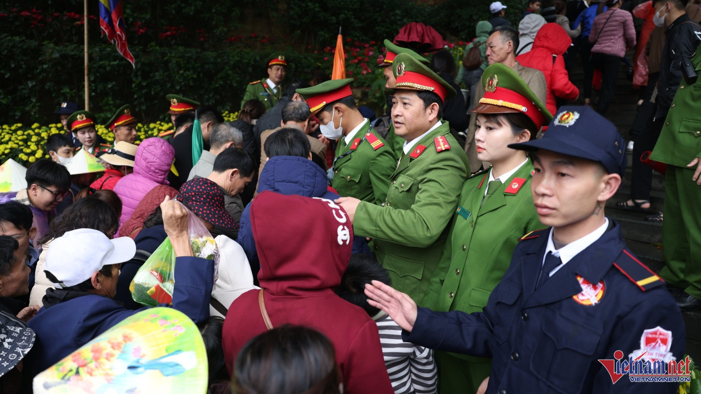 Để đảm bảo an toàn, lực lượng công an lập hàng rào mềm để mỗi lượt 3 người di chuyển qua cổng đền. Ảnh: Đức Hoàng. Để đảm bảo an toàn, lực lượng công an lập hàng rào mềm để mỗi lượt 3 người di chuyển qua cổng đền. Ảnh: Đức Hoàng.