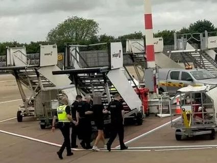 Những bức ảnh được chia sẻ với EdinburghLive cho thấy một người đàn ông bị bao vây bởi 4 sĩ quan cùng nhiều xe cảnh sát tại hiện trường khi chuyến bay hạ cánh. Ảnh: Mirror. Những bức ảnh được chia sẻ với EdinburghLive cho thấy một người đàn ông bị bao vây bởi 4 sĩ quan cùng nhiều xe cảnh sát tại hiện trường khi chuyến bay hạ cánh. Ảnh: Mirror.