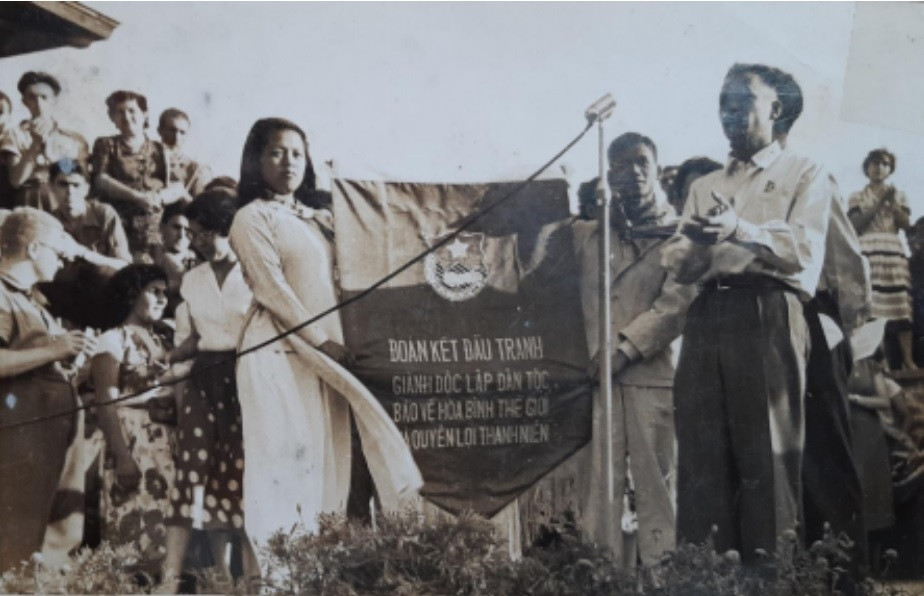 Ông Nguyễn Khánh và bà Đỗ Hồng Phấn cầm biểu ngữ, ông Vũ Quang đứng bên phải đang phát biểu tại Festival Bucarest, Rumania, 1953. Ông Nguyễn Khánh và bà Đỗ Hồng Phấn cầm biểu ngữ, ông Vũ Quang đứng bên phải đang phát biểu tại Festival Bucarest, Rumania, 1953.