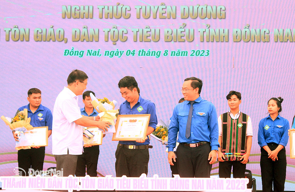 Đại diện Tỉnh đoàn và Huyện ủy Định Quán trao bằng khen và hoa cho thanh niên dân tộc tiêu biểu