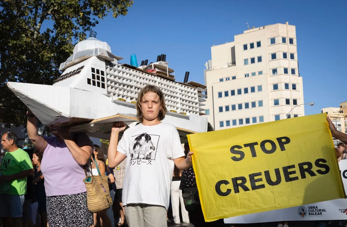 Một thanh niên cầm tấm biển có dòng chữ "Dừng hoạt động du thuyền" trong cuộc biểu tình vào ngày 21/7.