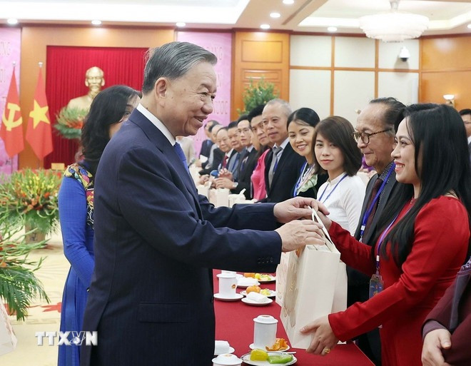 Tổng Bí thư Tô Lâm tặng quà cho kiều bào tiêu biểu tham dự chương trình "Xuân quê hương" năm 2025. (Ảnh: Thống Nhất/TTXVN)