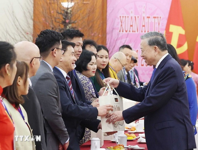 Tổng Bí thư Tô Lâm tặng quà cho kiều bào tiêu biểu tham dự chương trình "Xuân quê hương" năm 2025. (Ảnh: Thống Nhất/TTXVN)