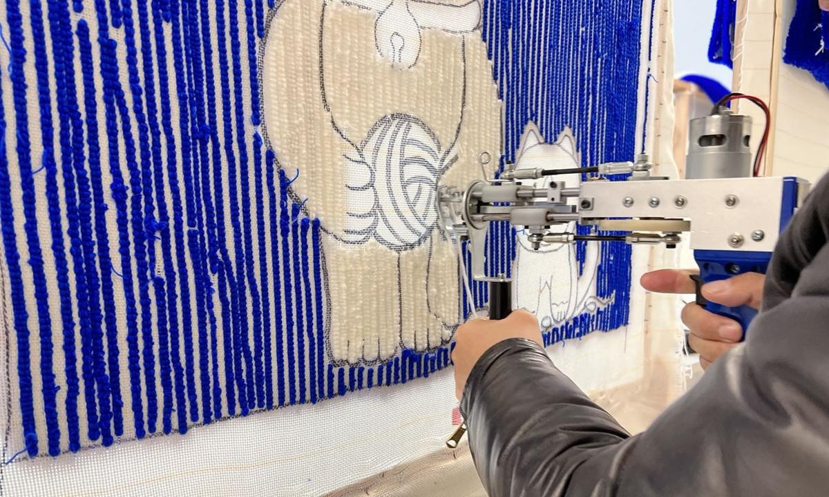 Chủ một xưởng ở Bắc Kinh trình diễn cách thêu mới. Ảnh: Lou Kang / GT Chủ một xưởng ở Bắc Kinh trình diễn cách thêu mới. Ảnh: Lou Kang / GT