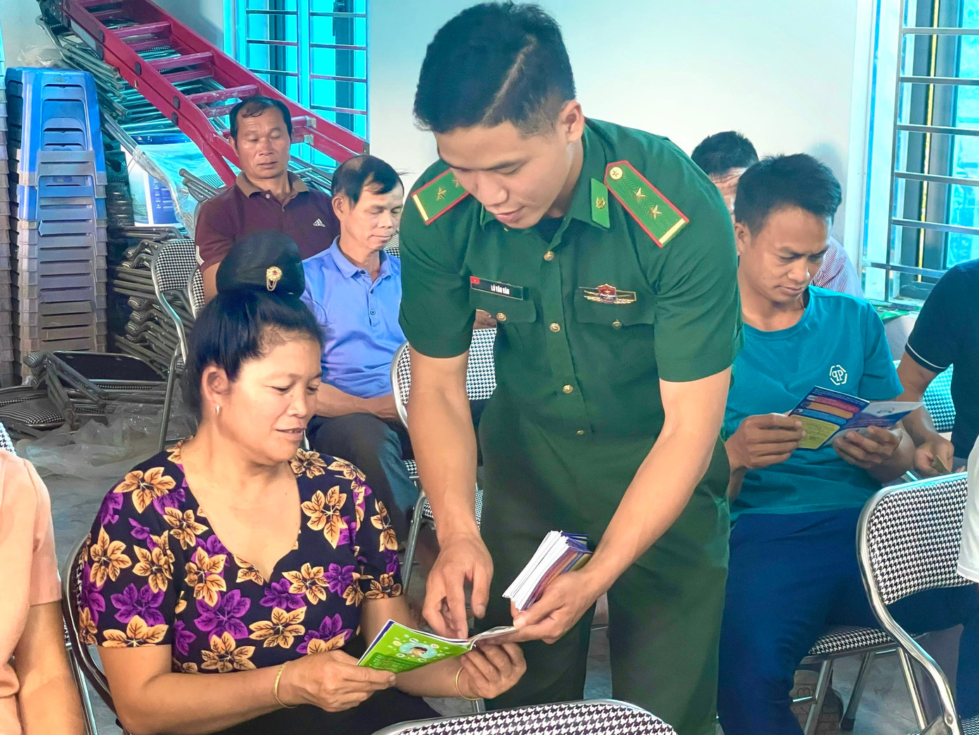 Cán bộ Đồn Biên phòng Mường Lạn phát tờ gấp tuyên truyền pháp luật cho bà con dân tộc thiểu số tại xã biên giới Nậm Lạnh, huyện Sốp Cộp, tỉnh Sơn La. Ảnh: Quàng Hùng.