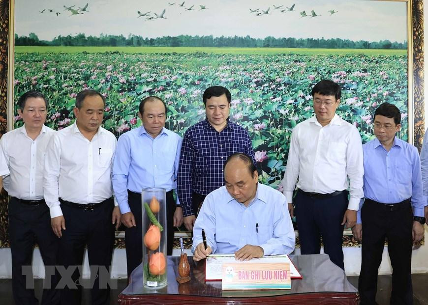 Chủ tịch nước Nguyễn Xuân Phúc viết cảm tưởng vào Sổ vàng tại Khu di tích cụ Phó bảng Nguyễn Sinh Sắc. (Ảnh: Thống Nhất/TTXVN)