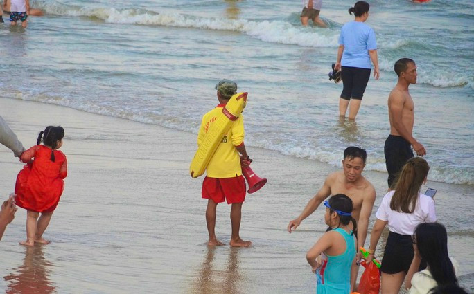 Đúng 18 giờ tối, lực lượng cứu hộ hú còi, bắc loa yêu cầu du khách và người dân địa phương ngừng tắm biển, lên bờ để bảo đảm an toàn